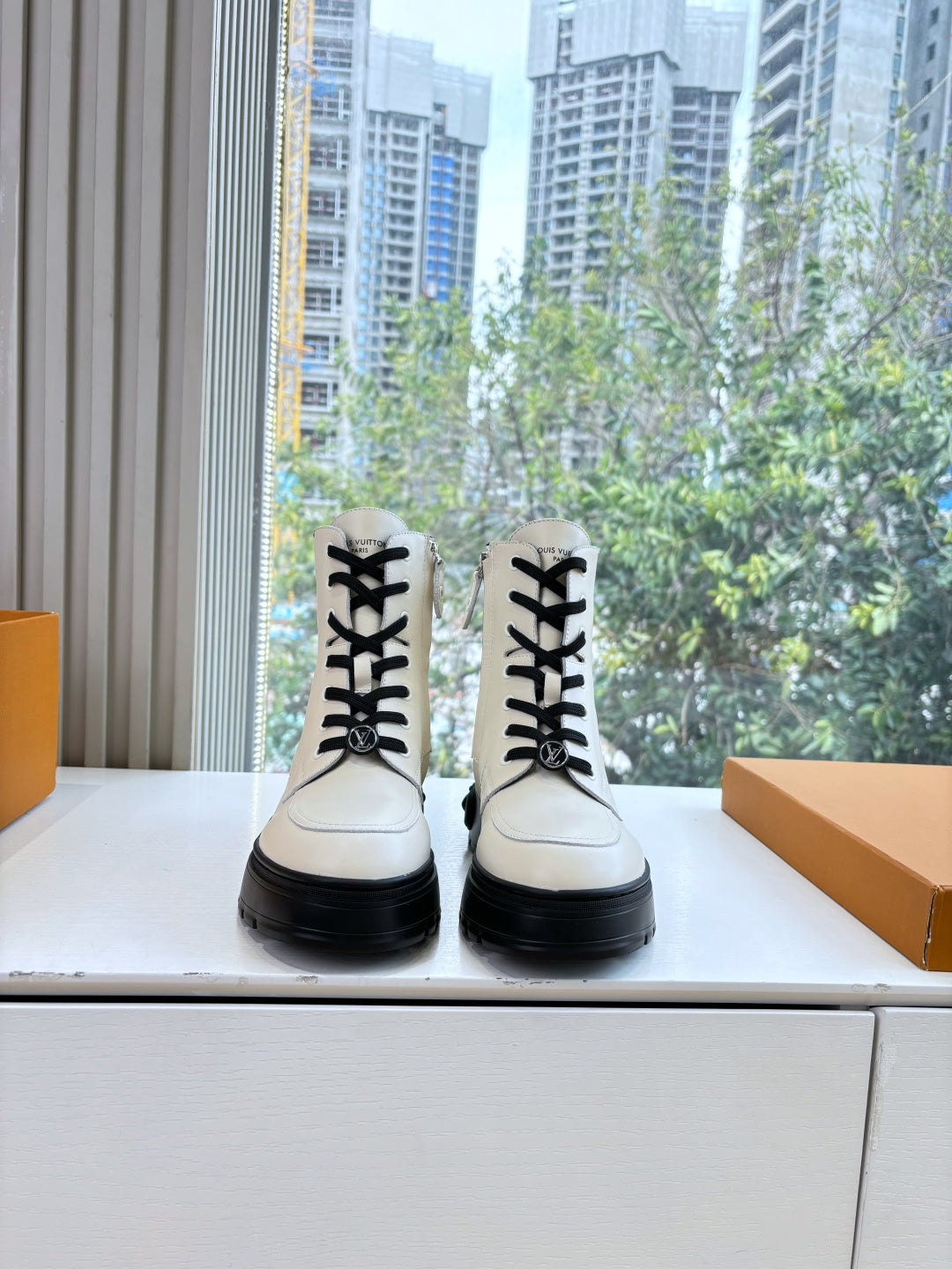 White leather ankle boots with black laces and chunky black rubber soles