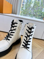 White leather ankle boots with Louis Vuitton emblem, black laces, chunky soles