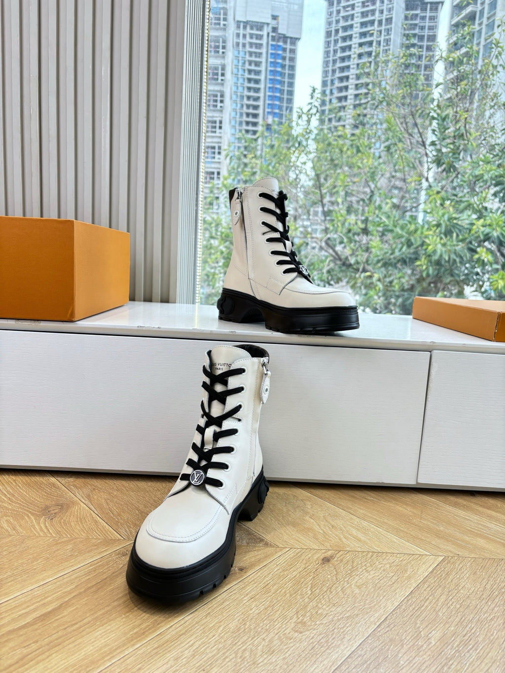 White leather lace-up ankle boots with black laces and oversized treaded soles