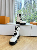 White leather lace-up ankle boots with black laces and oversized treaded soles