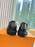 Louis Vuitton leather loafers, black, rear view showing stamped logo on heel