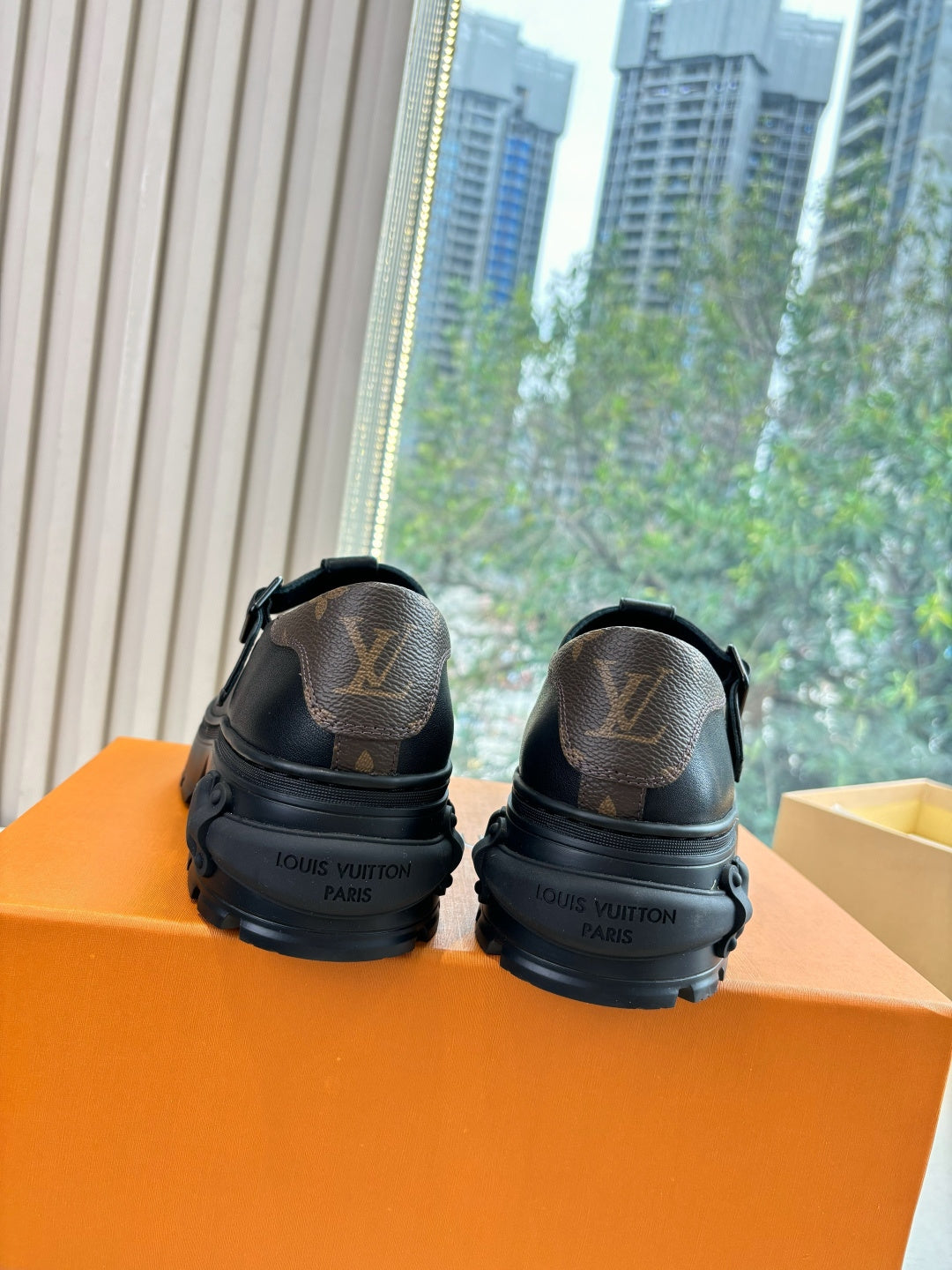 Louis Vuitton leather loafers, black, rear view showing stamped logo on heel