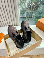 Pair of monogram slip-on shoes, dark brown fabric uppers with black buckle straps