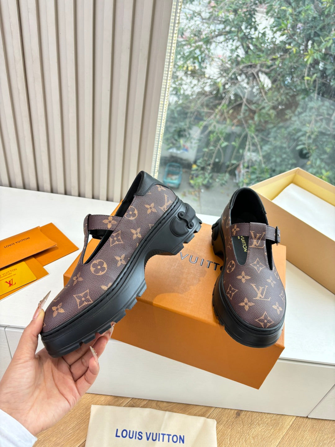 Monogram slip-on shoes, dark brown patterned uppers with black buckle strap and sole