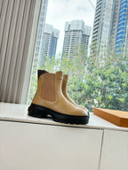 Tan leather Chelsea boot with elastic side panels and chunky black sole.