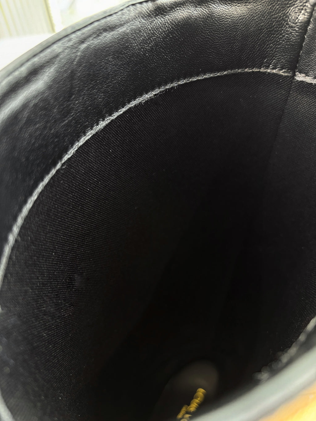 Close-up of black leather knee-high boot interior and stitching