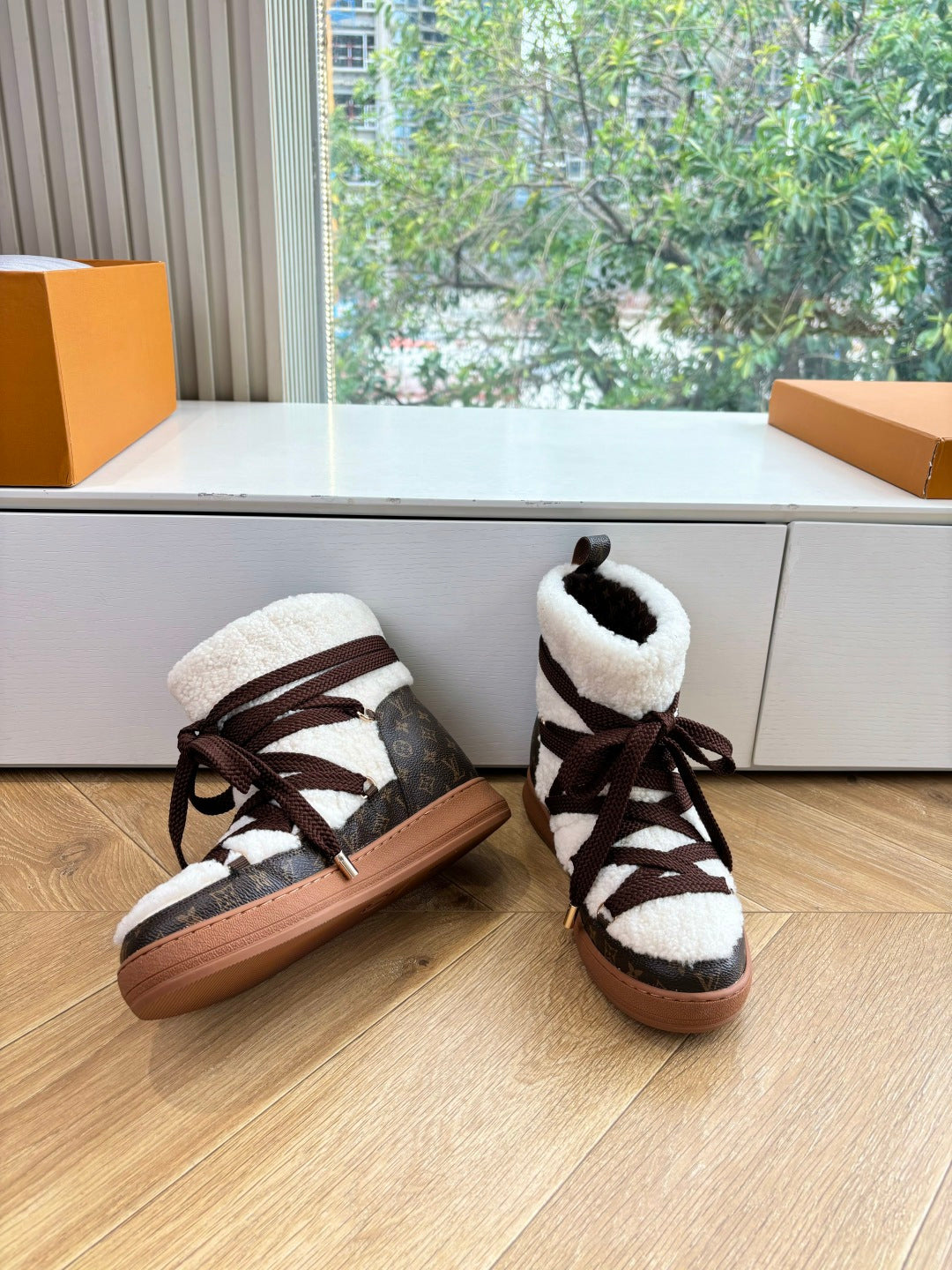 Pair of high-top sneakers with dark laces, white shearling lining, and tan rubber soles