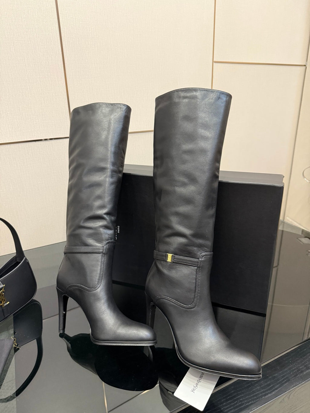 YSL ladies knee-high black leather boots, pair view with gold buckle