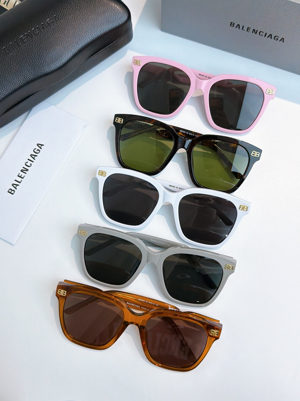 Balenciaga sunglasses set: pink, green, white, and amber frames with dark lenses.