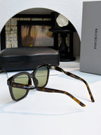 Balenciaga sunglasses with tortoiseshell frames and green-tinted lenses, side view.