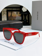 Red sunglasses with gold emblem on temple and dark lenses