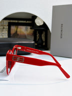Red sunglasses side view with gold logo detail