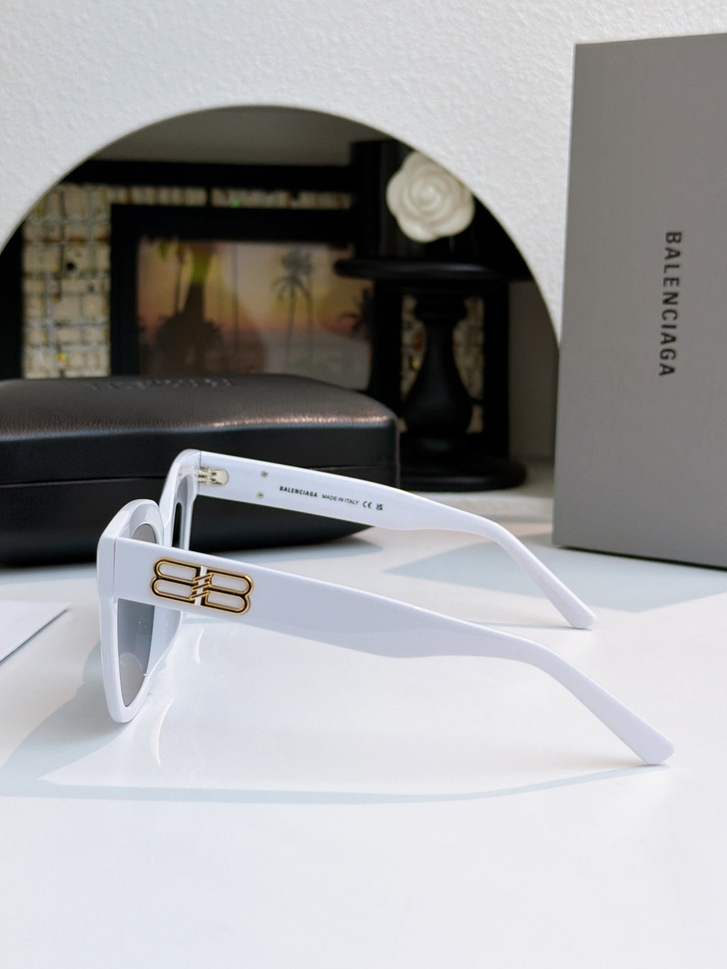 White sunglasses side view with gold logo bar on arm