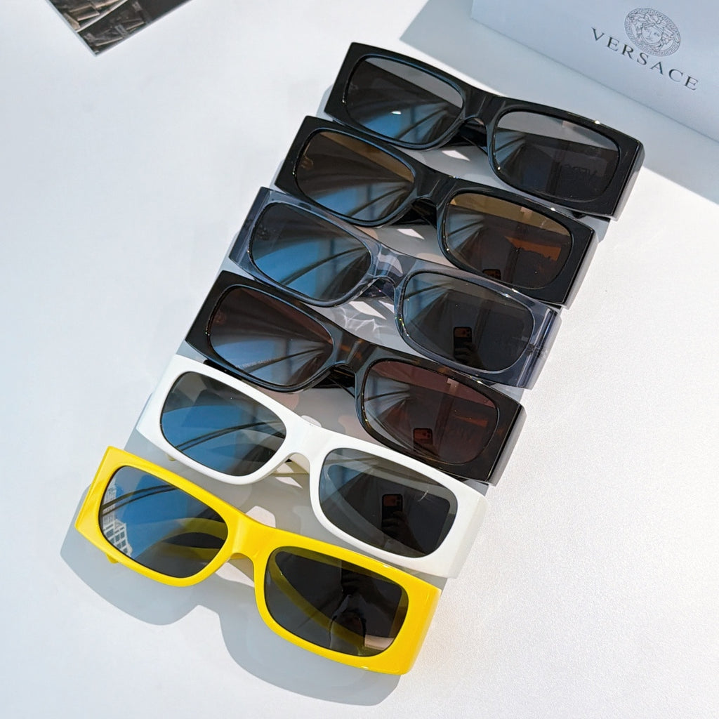 Set of Versace sunglasses on display, yellow, blue, and dark frames with logos.