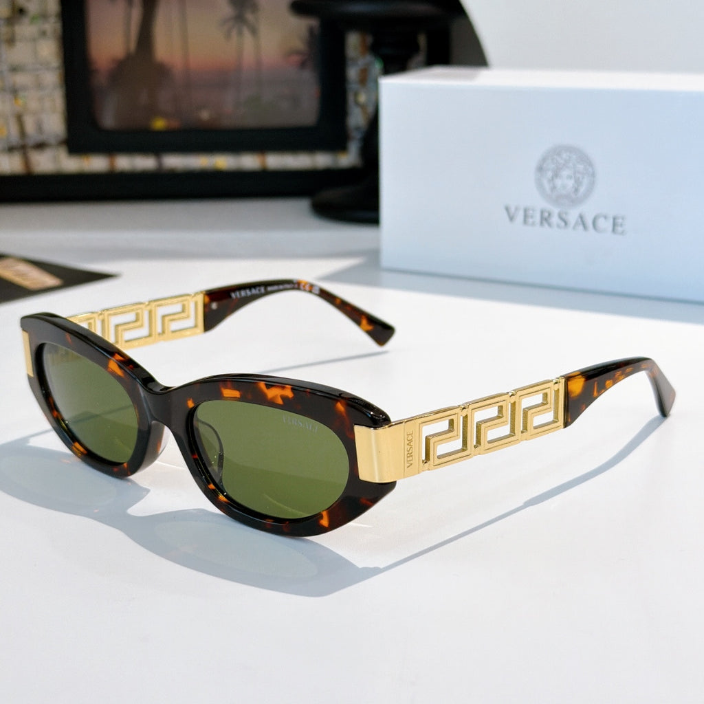 Versace cat-eye sunglasses with dark tortoise frame, gold Greek key temples, and green lenses