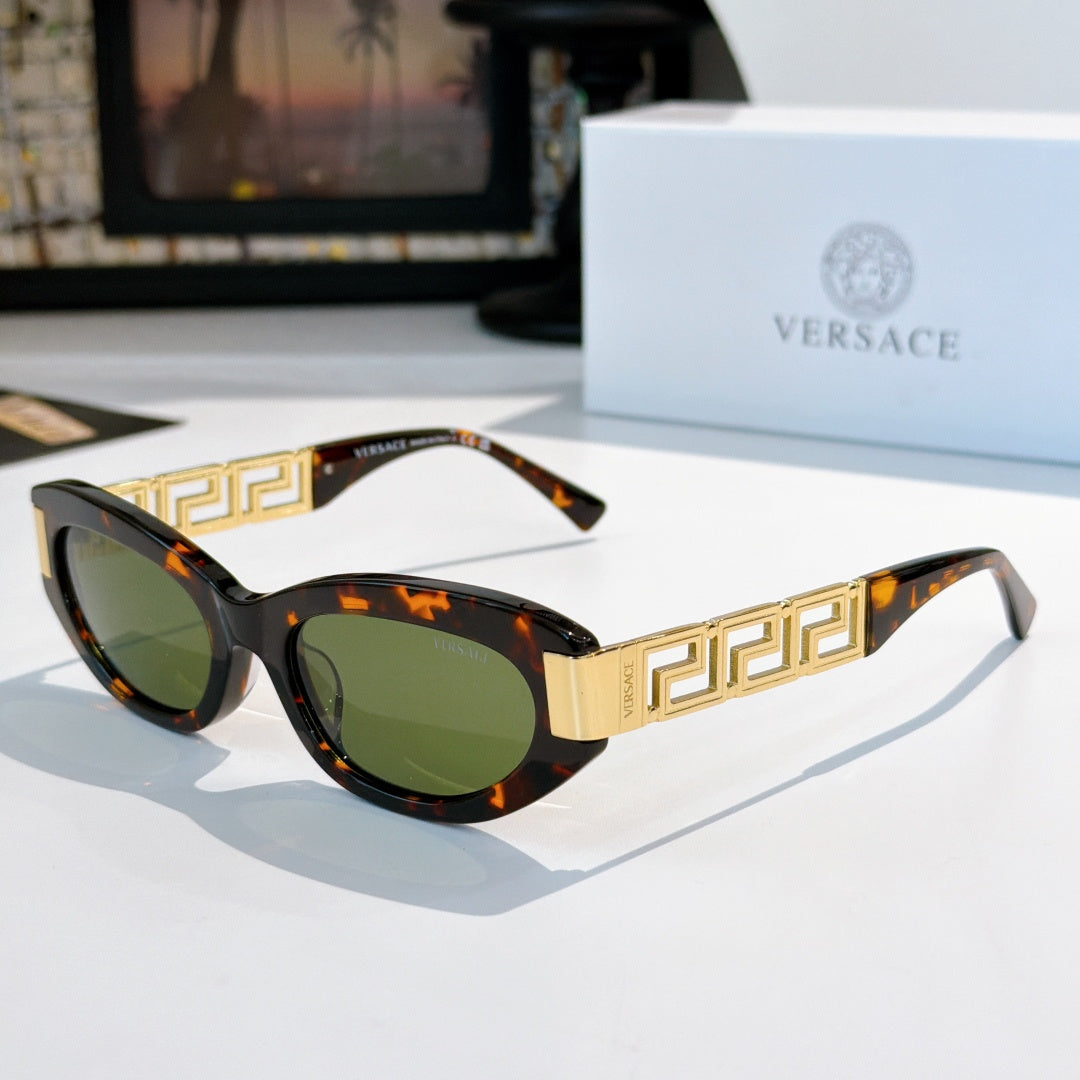 Versace cat-eye sunglasses with dark tortoise frame, gold Greek key temples, and green lenses