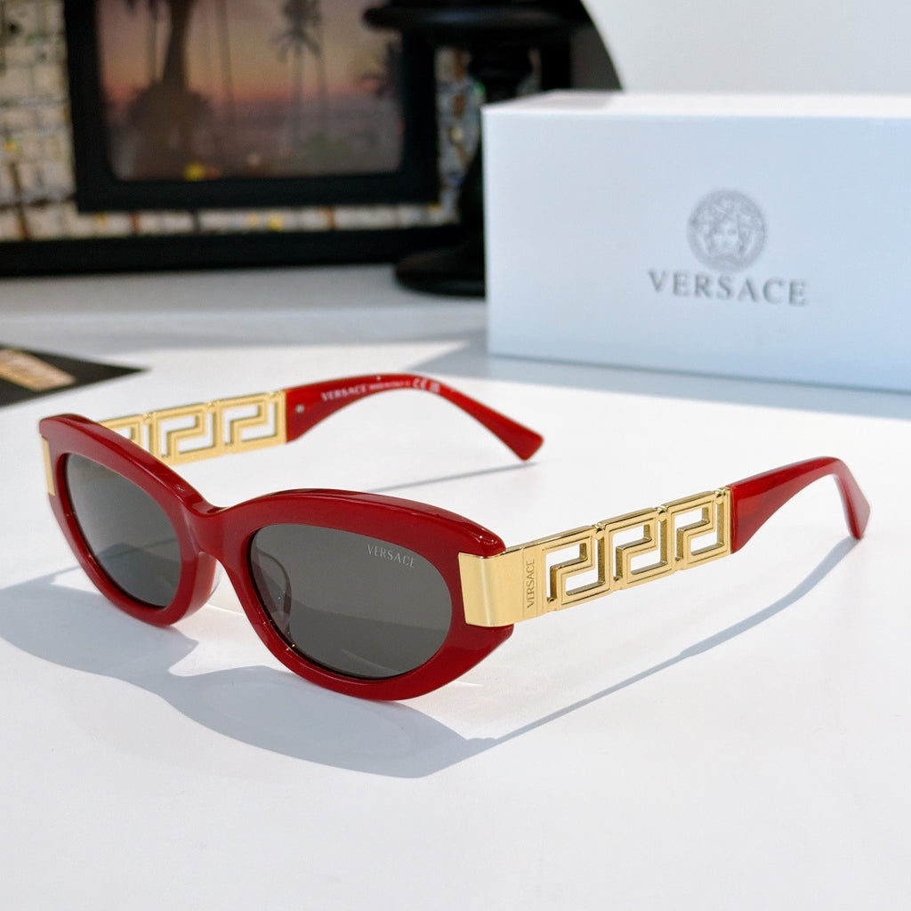 Versace cat-eye sunglasses with red frame, gold Greek key temples, and dark tinted lenses