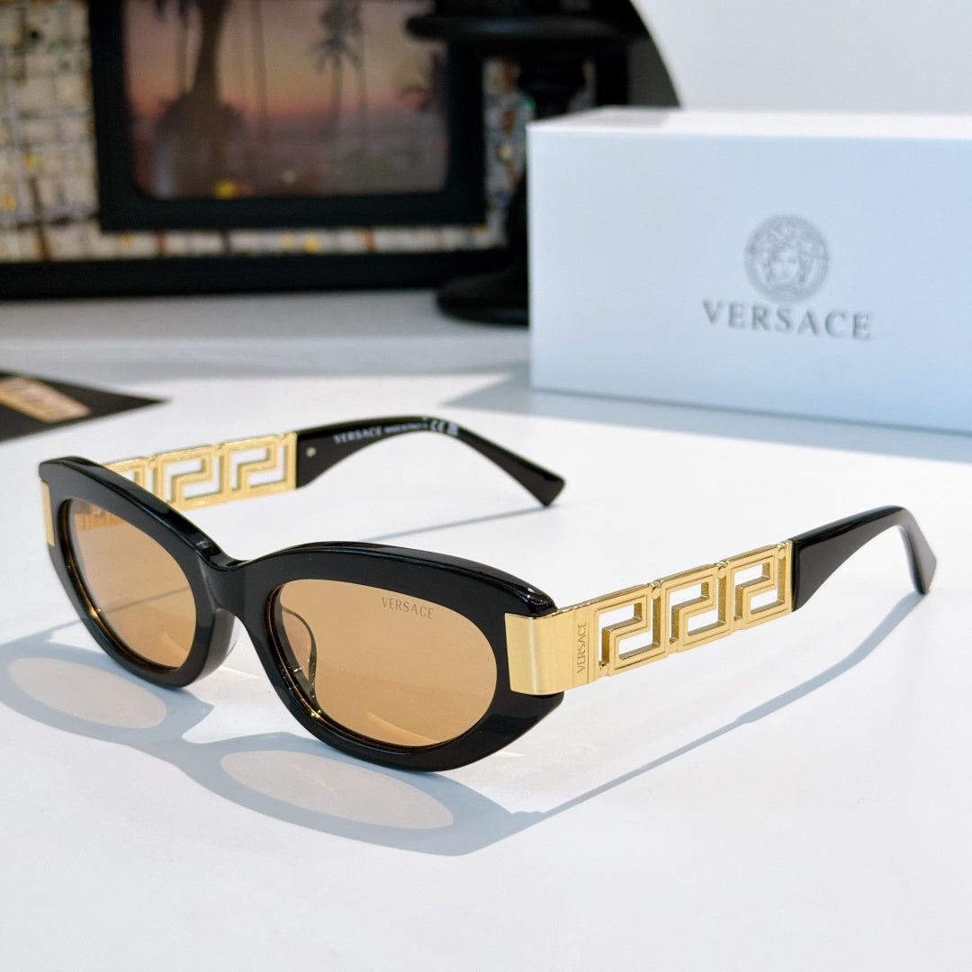 Versace round cat-eye sunglasses with black frame, gold Greek key temples, and brown lenses