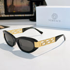 Versace cat-eye sunglasses with black frame, gold Greek key temples, and dark tinted lenses