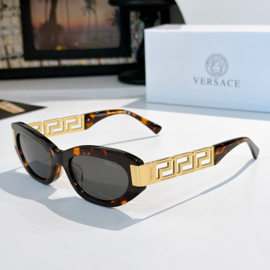 Versace cat-eye sunglasses with tortoise frame, gold Greek key temples, and dark lenses
