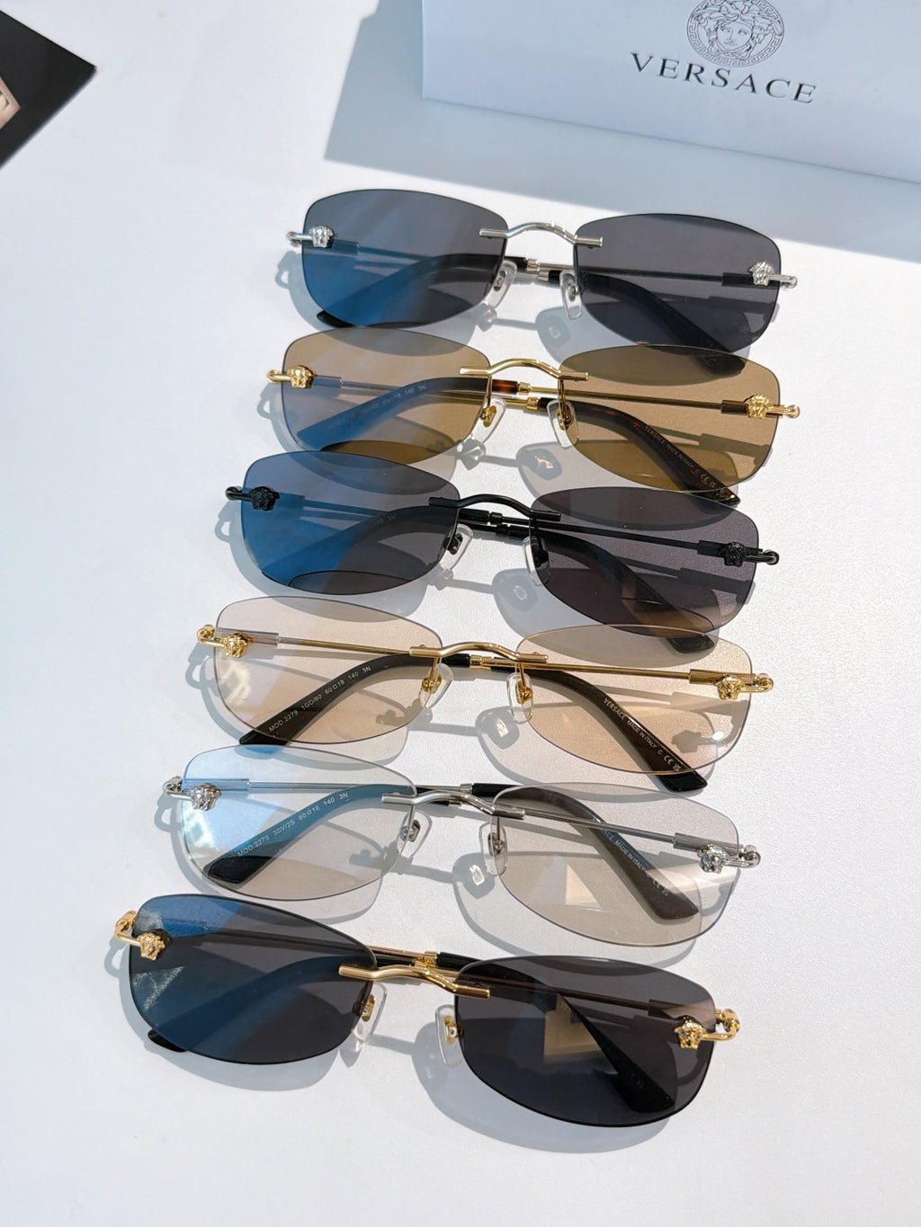 Stack of sunglasses with mixed frames and blue, brown, and dark lenses