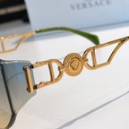 Gold monogram-detail sunglasses with light blue mirrored lenses and green temple tips.