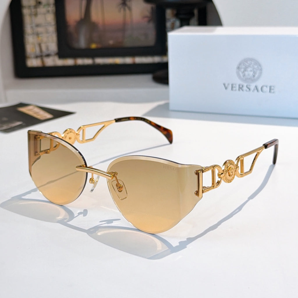 Gold-frame cat-eye sunglasses with light tan mirrored lenses and tortoise detail.