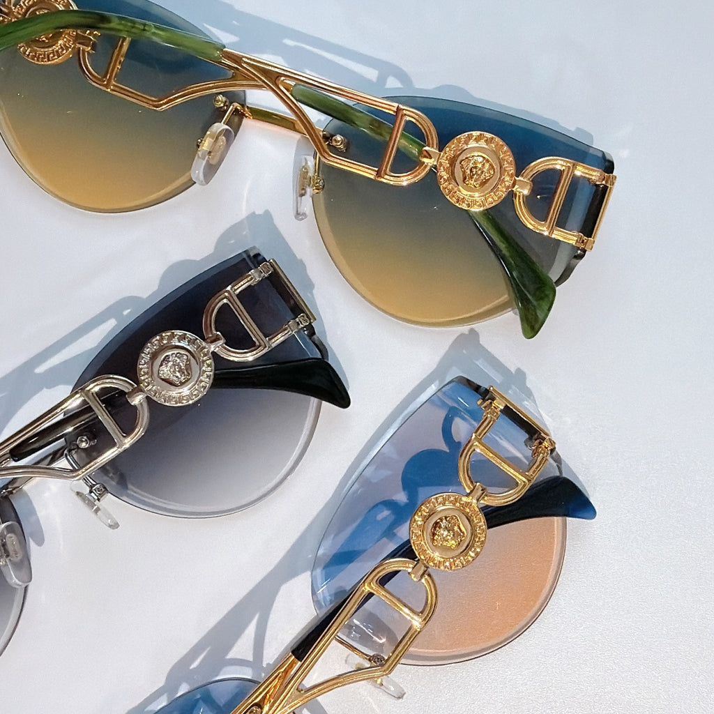 Three gold-frame cat-eye sunglasses with blue and tan gradient mirrored lenses.
