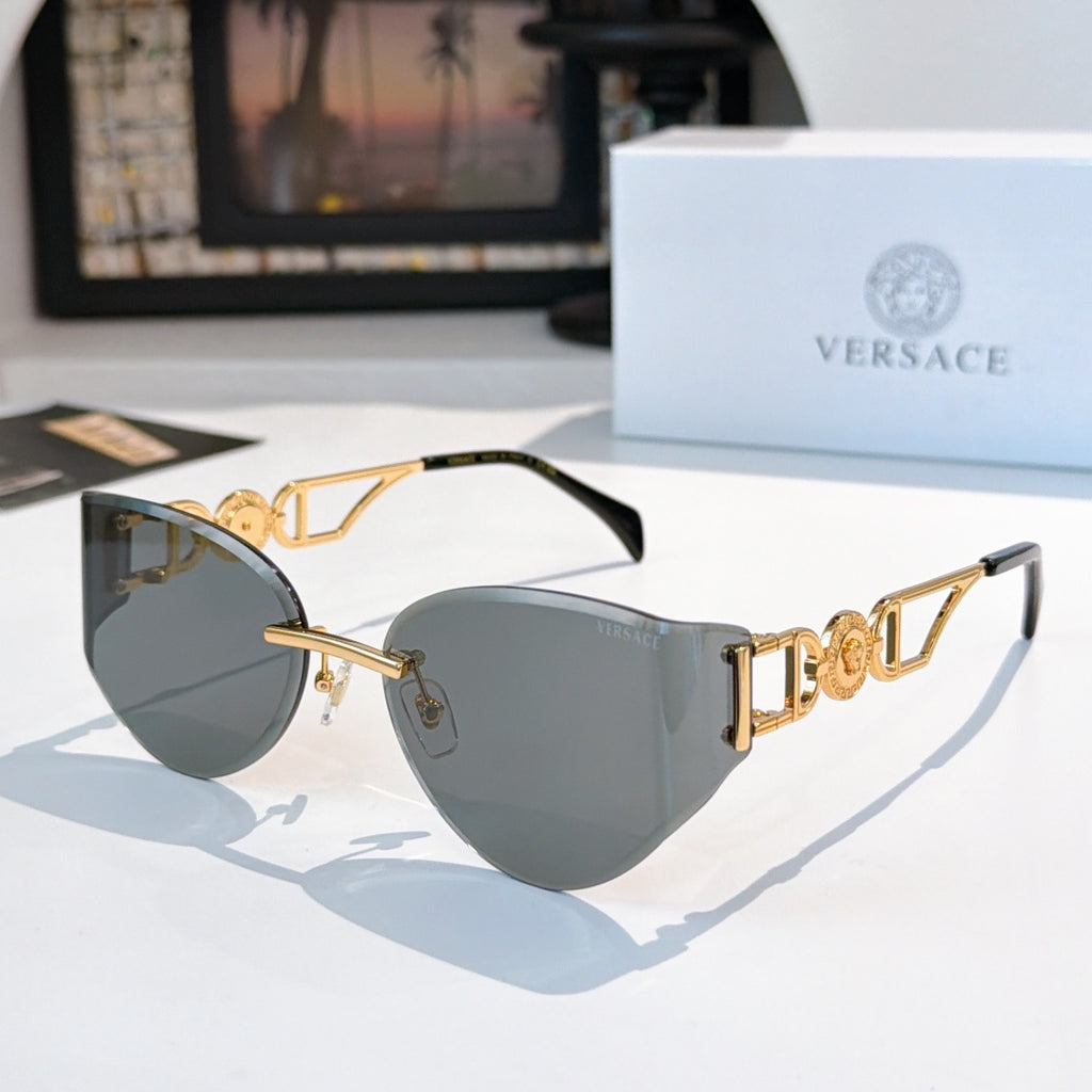 Gold-frame cat-eye sunglasses with dark gray mirrored lenses.