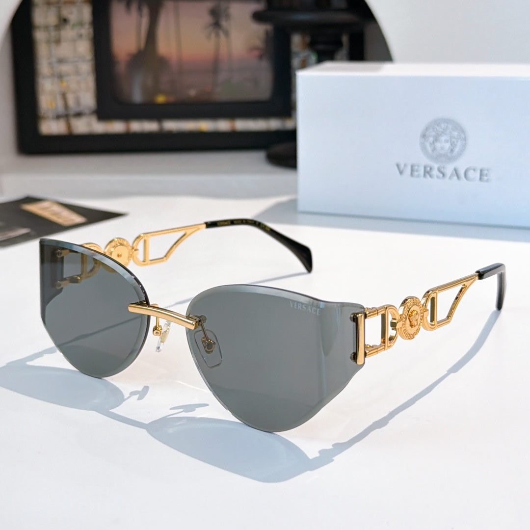 Gold-frame cat-eye sunglasses with dark gray mirrored lenses.