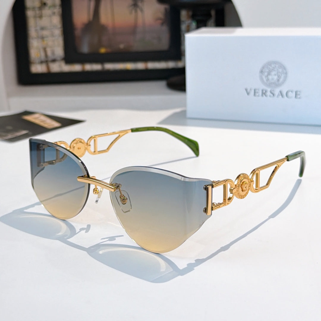 Gold-frame cat-eye sunglasses with light blue mirrored lenses and green temple tips.