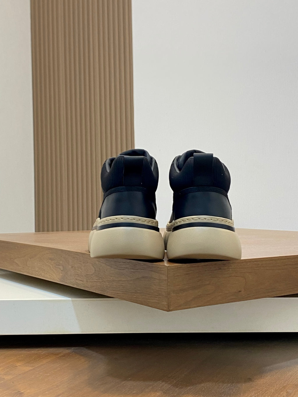 Black sneakers with rear heel tab and beige rubber sole