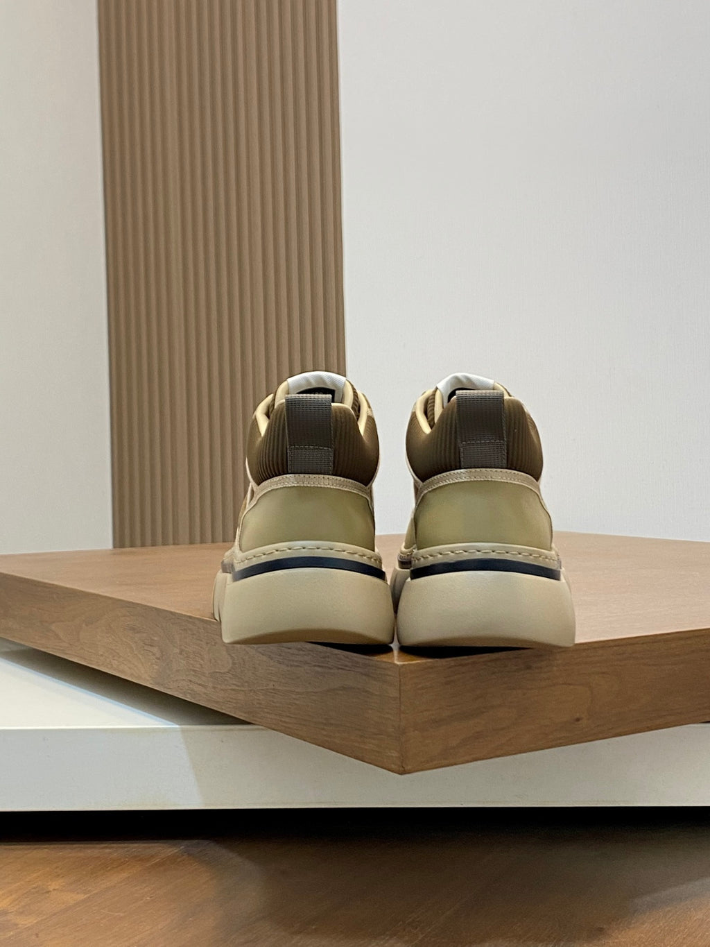 Luxury sneakers heel view, olive uppers with beige collars and back tab