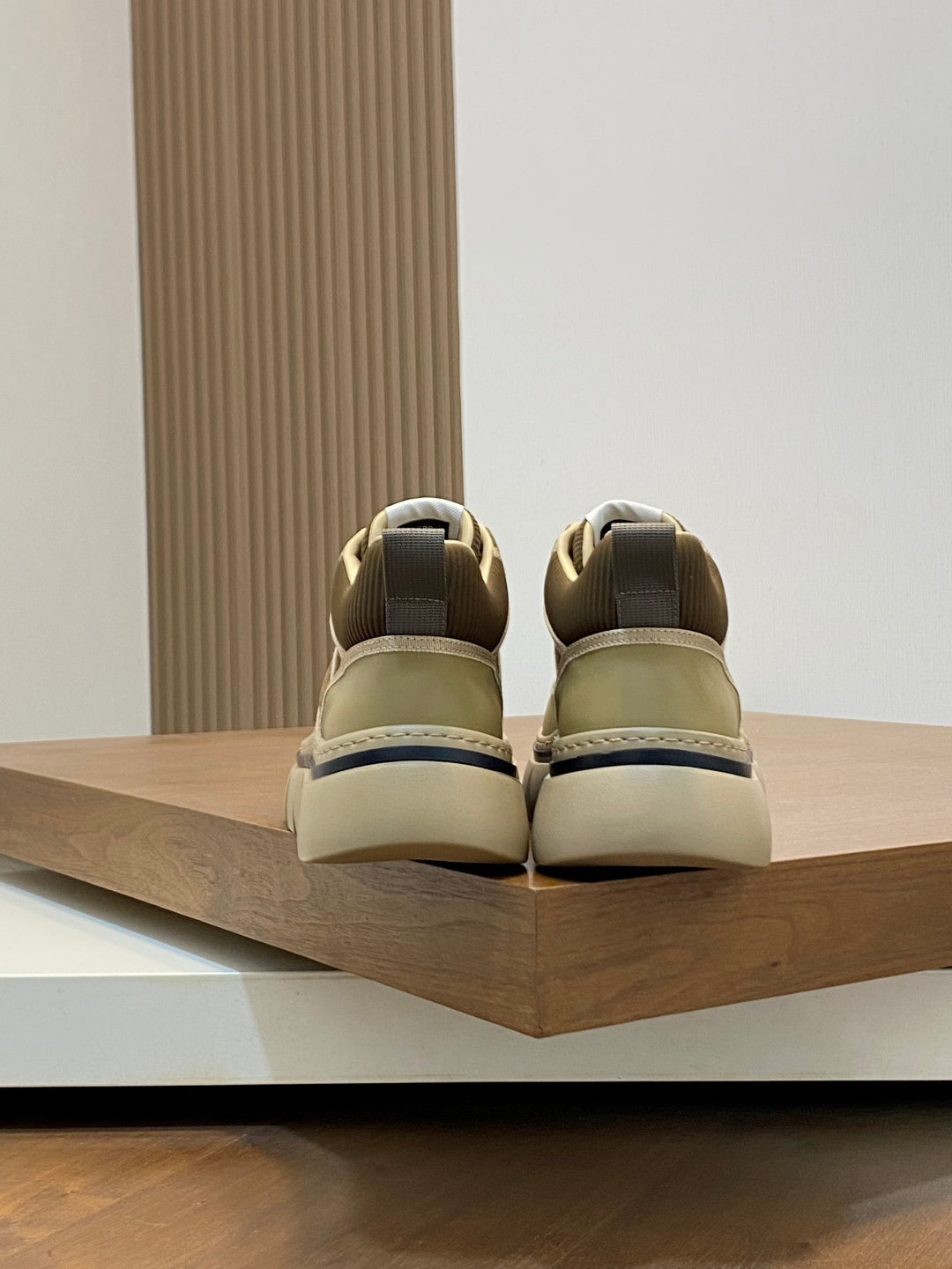 Luxury sneakers heel view, olive uppers with beige collars and back tab