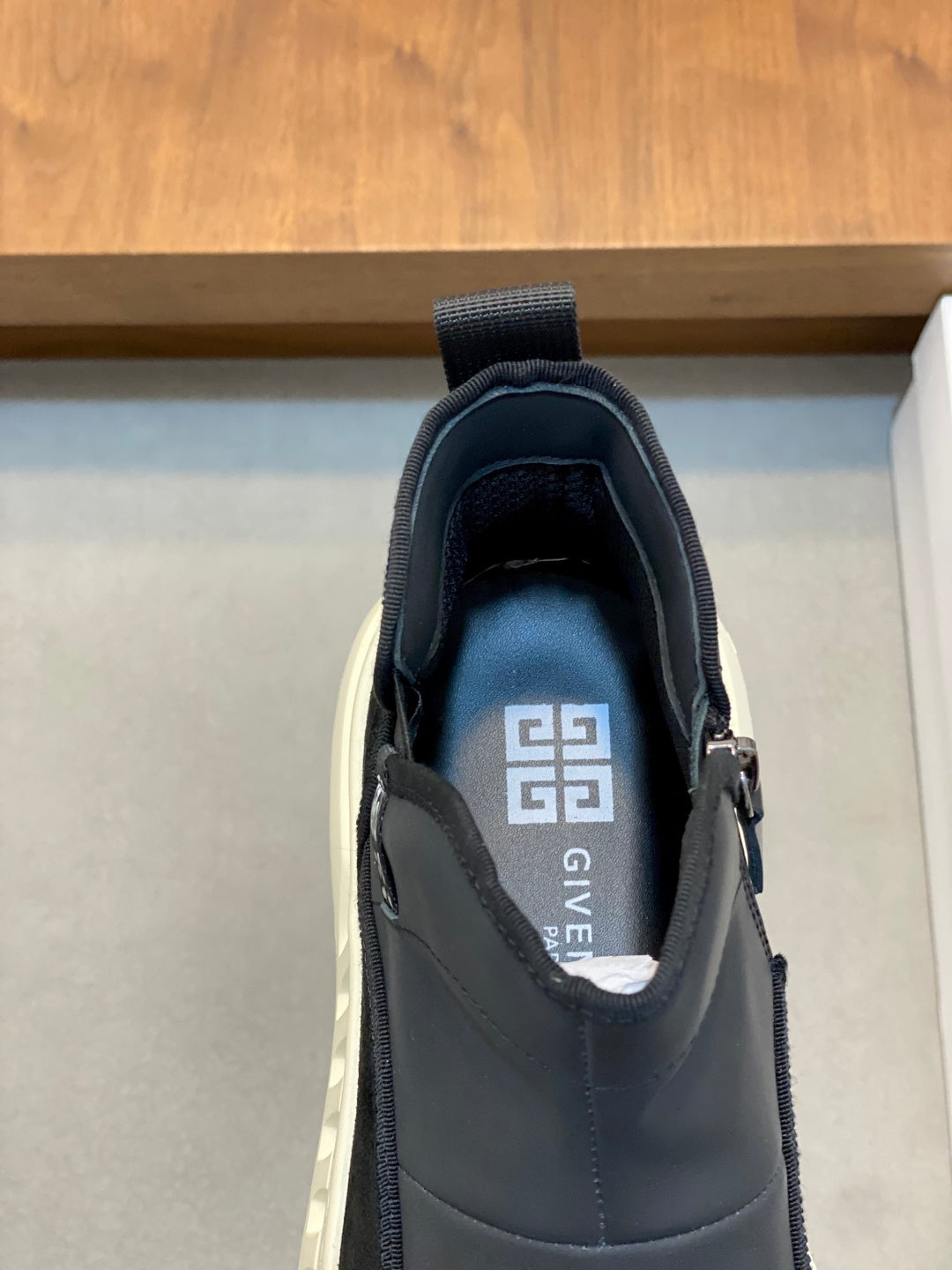 Givenchy dark sneakers with tongue label and stitched logo, close-up