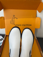 Pair of white pull-on chelsea boots with black elastic side panels