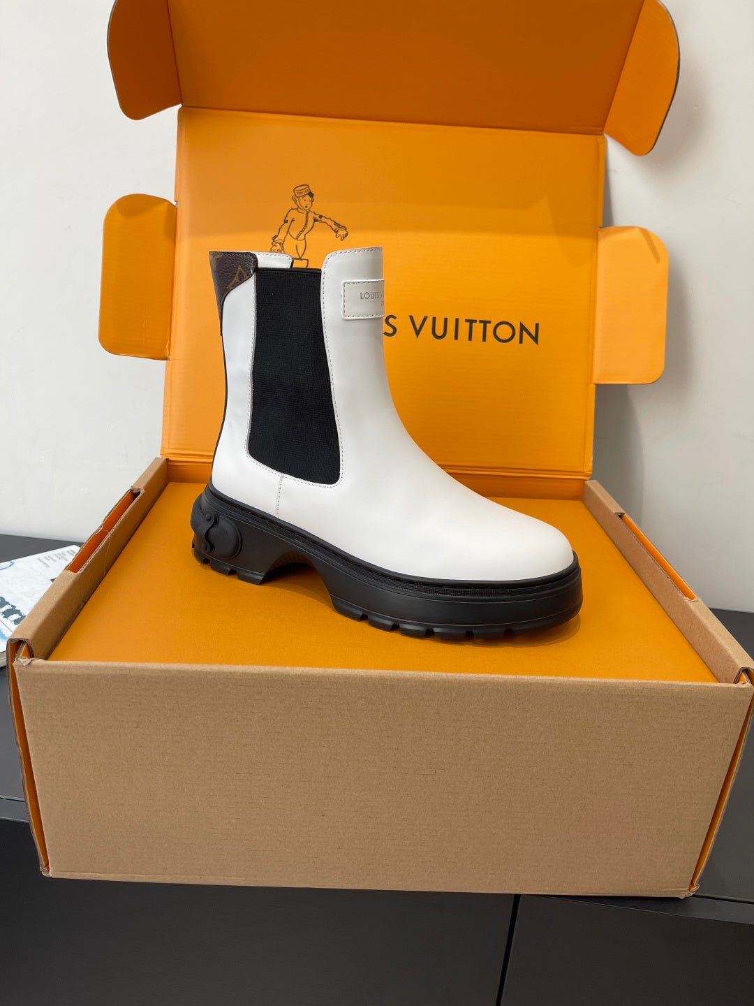 White chelsea boots with black side gussets, pull-on style, chunky lug soles