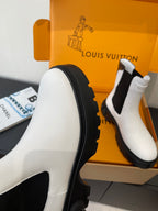 White chelsea boot side view with black rubber edge and chunky lug sole