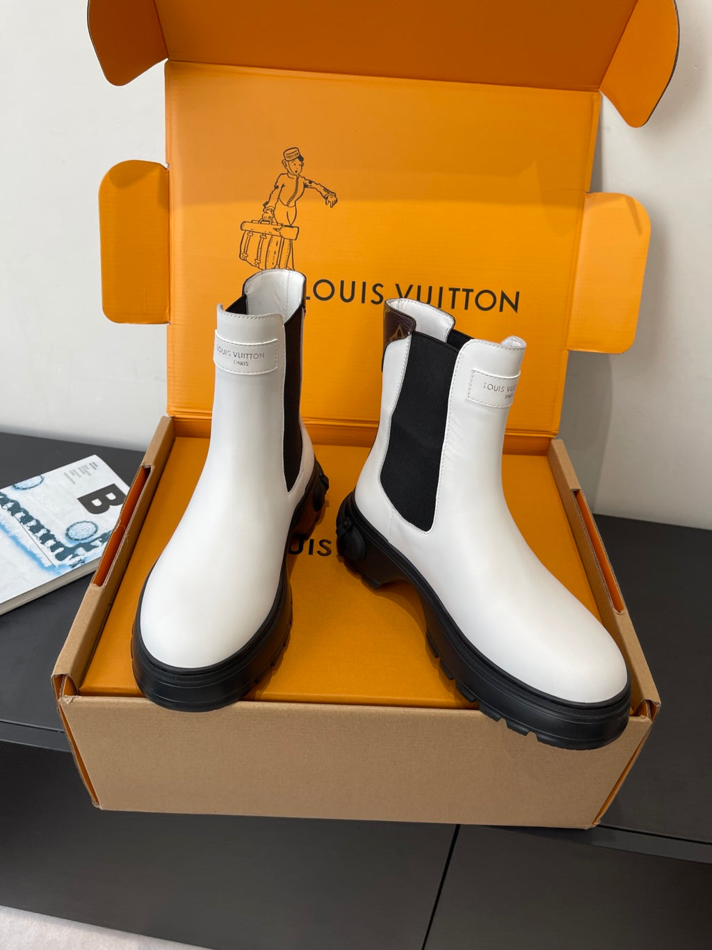 Pair of Louis Vuitton white chelsea boots with black side panels and lug soles