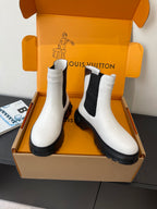 Pair of Louis Vuitton white chelsea boots with black side panels and lug soles
