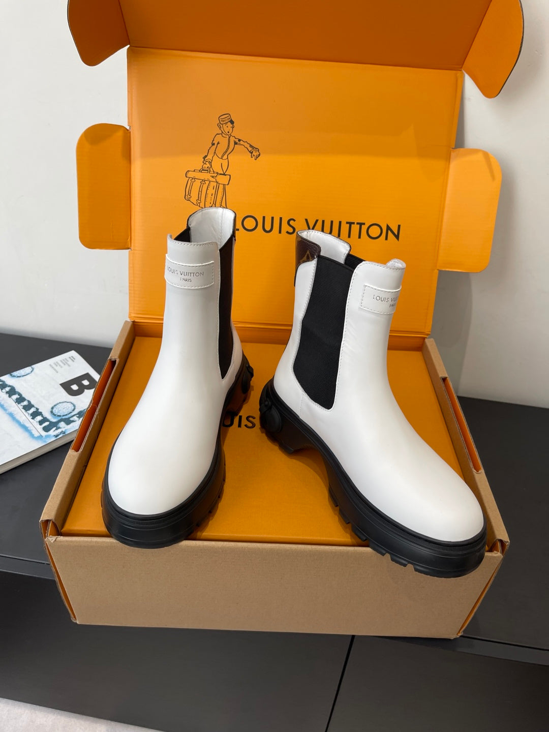 Pair of Louis Vuitton white chelsea boots with black side panels and lug soles