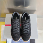 Black lace-up low-top sneakers with Prada Milano branding and gum rubber sole.