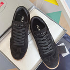 Black lace-up low-top sneakers with Prada logo, gum rubber sole, suede upper.