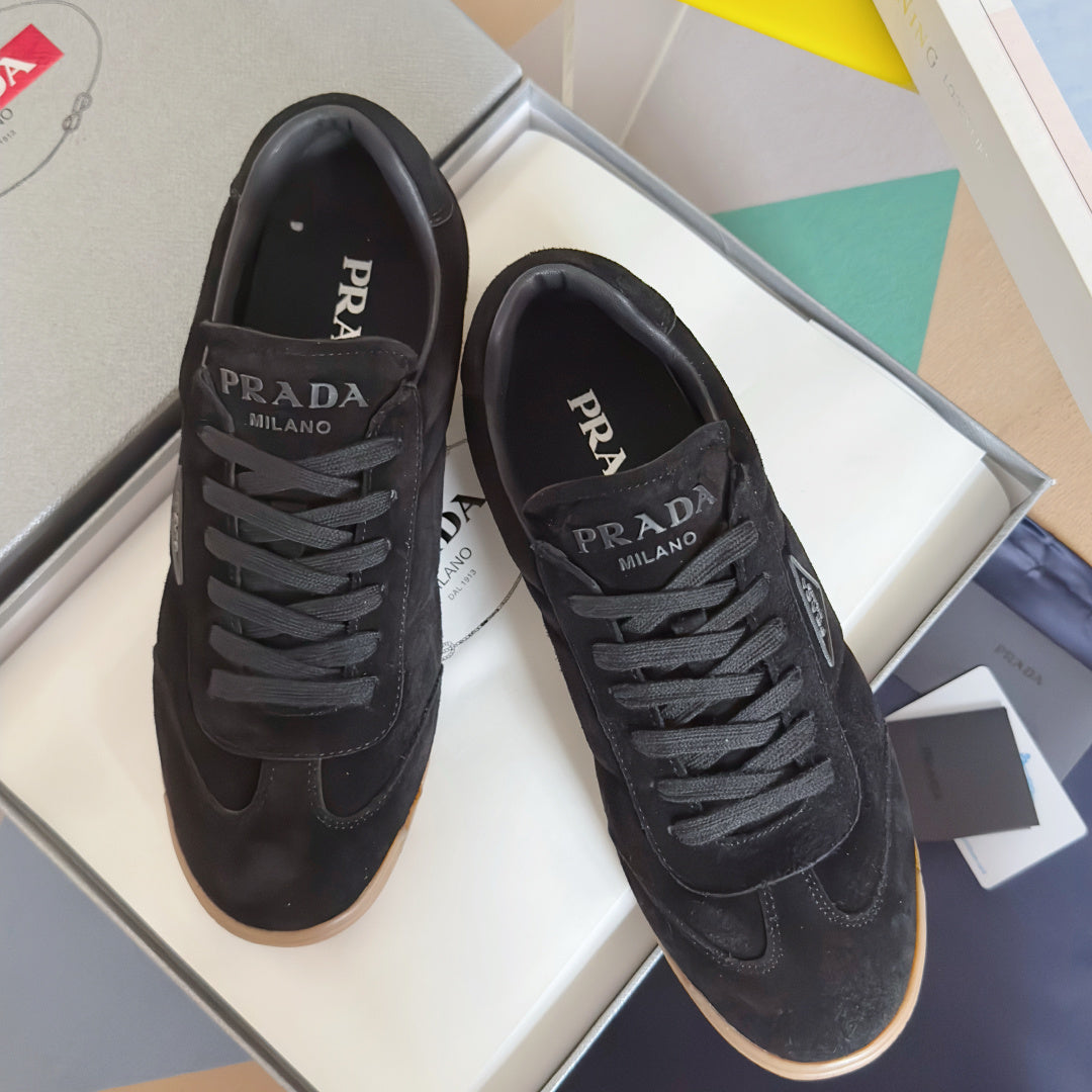 Black lace-up low-top sneakers with Prada logo, gum rubber sole, suede upper.