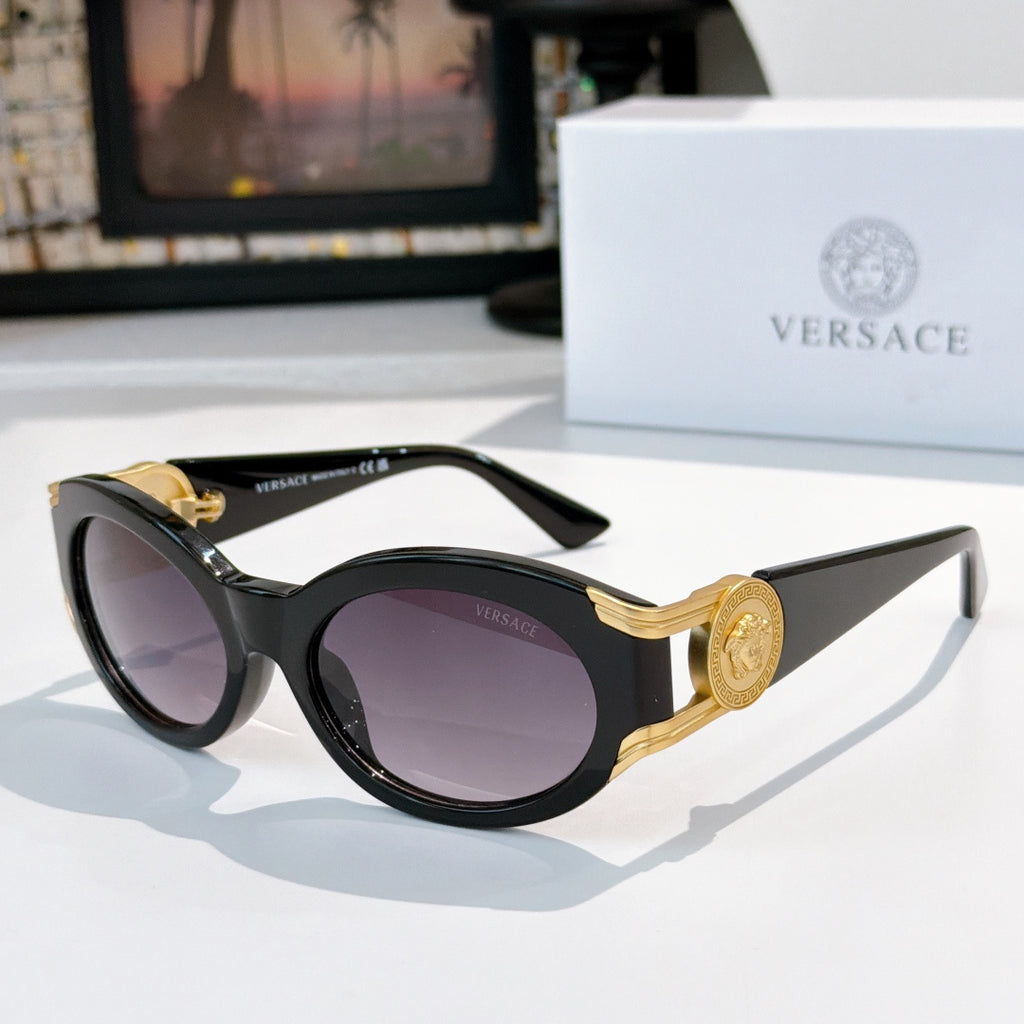 Round sunglasses with black frame, gold-tone arms, and purple tinted lenses