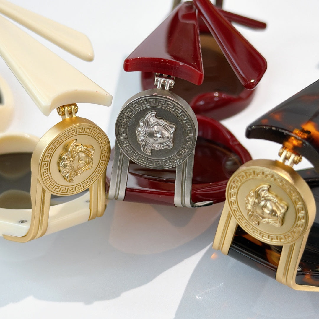 Close-up of sunglasses frames with gold medallion hinges in cream, red, and dark tortoise