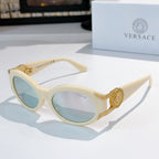 Cat-eye sunglasses with light cream frame, gold-tone arms, and light blue tinted lenses