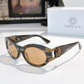 Round sunglasses with dark blue patterned frame, gold-tone arms, and tan tinted lenses