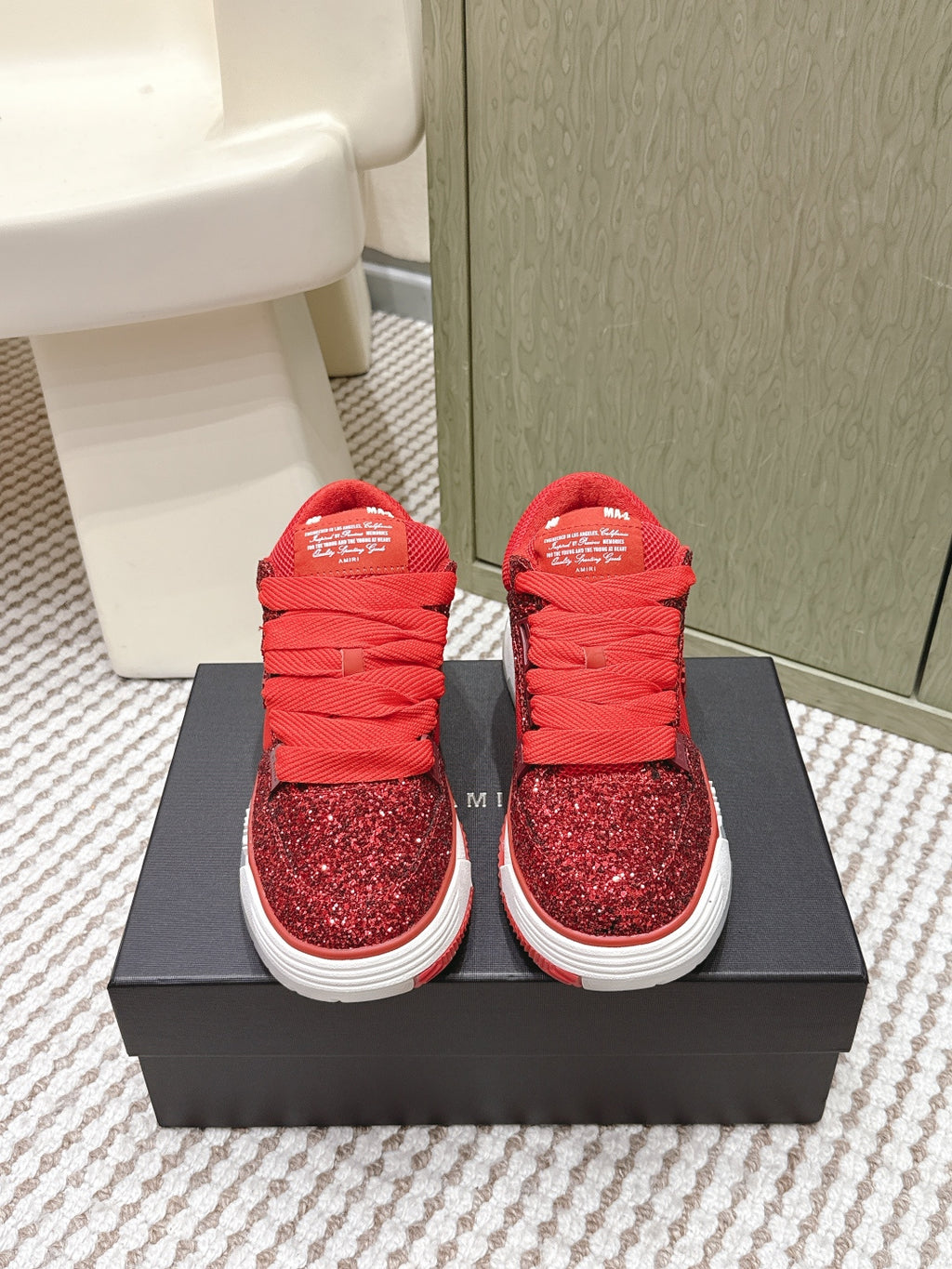 Red glitter lace-up sneakers with white sole and Amiri logo, on box