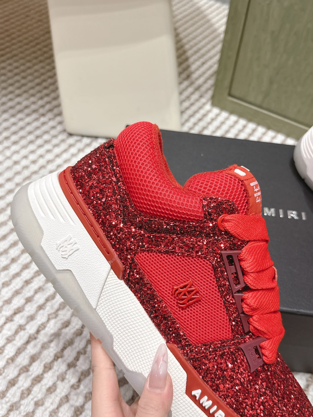 Close-up of red glitter lace-up sneakers with textured upper and white sole